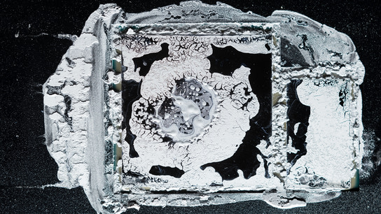 Thermal compound paste smeared all over a CPU and the surrounding area.