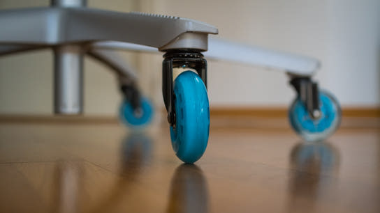 An office chair with rollerblade-style wheels.